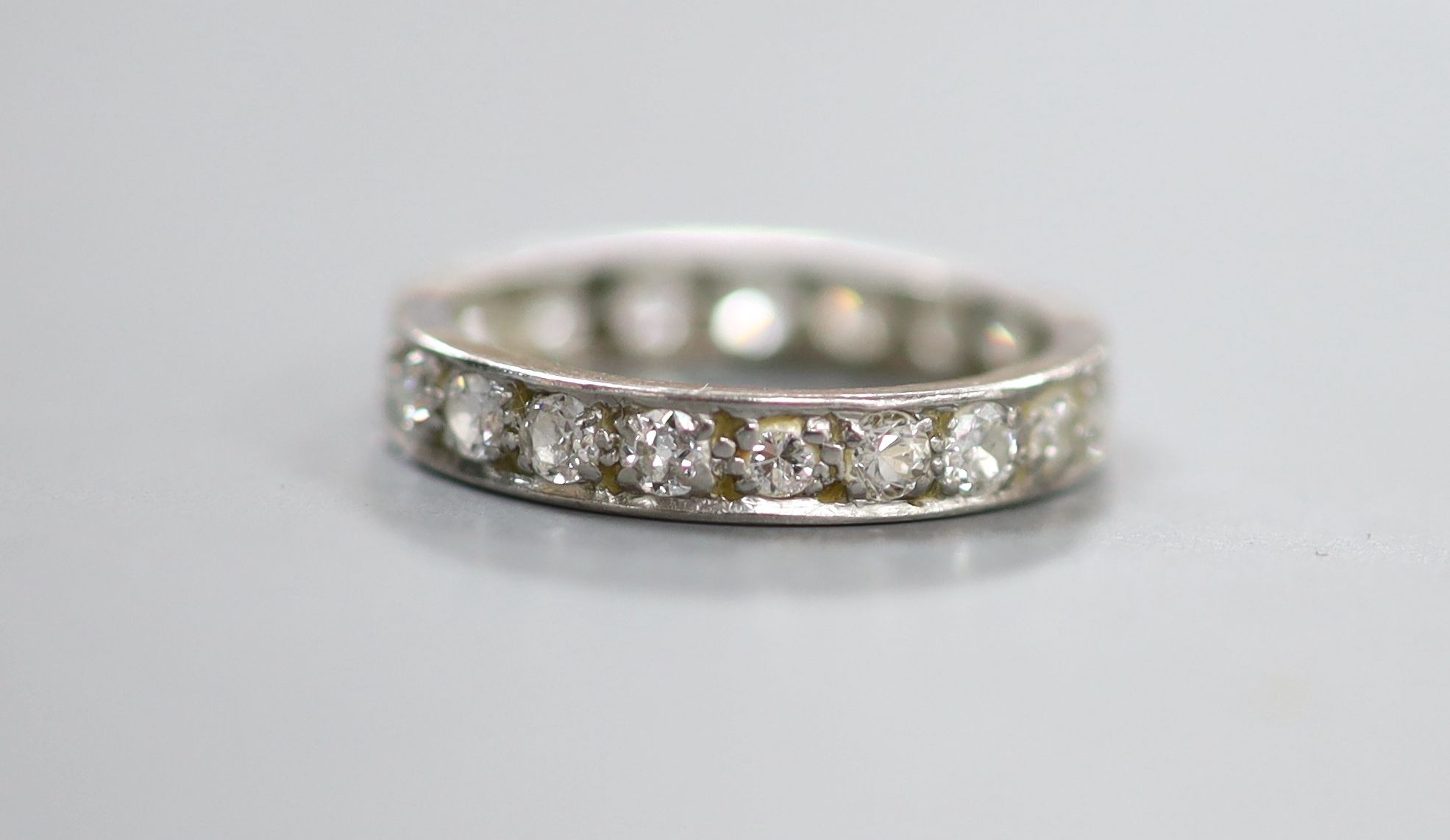 A white metal and diamond set full eternity ring, size K/L, gross 2.5 grams.
